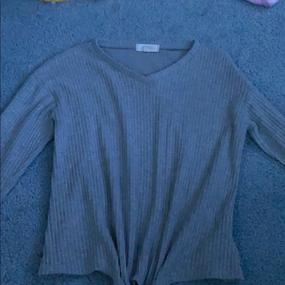 A gray sweater with a tie at the bottom